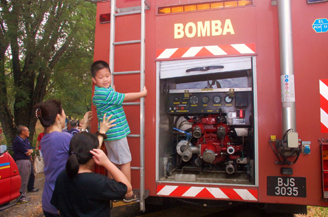 Child climbing up the ladder of a fire engine