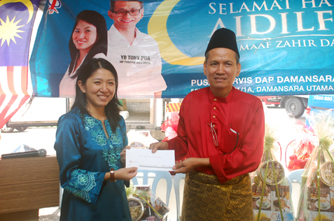 Persatuan Penduduk Rumah Pangsa Damansara Bistari chairman Abdul Samad Abdul Rashid receives a contribution from Yeo Bee Yin.
