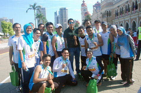 Youth and Sports minister Khairy Jamaluddin (centre, with sunglasses) posing with participants after the marathon race.