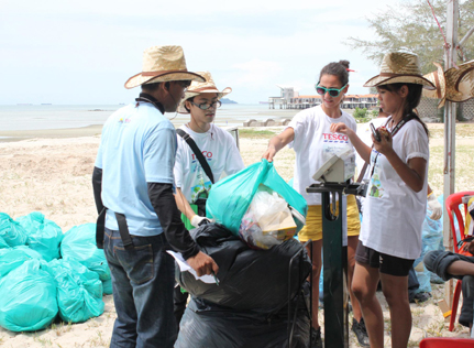 Tesco employees collecting litter along Port Dickson beach