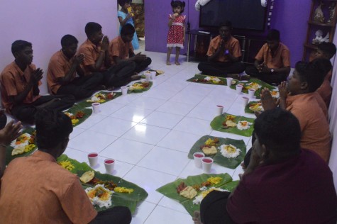 Children from the ashram saying their prayers before enjoying their dinner