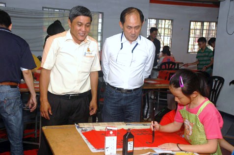 MBPJ councillor Sean Oon Chong Ling (right) and JKKK Sg Way chairman Ding Eow Chai looking at Koh's calligraphy skill.