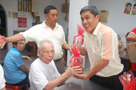 JKKK Sungai Way chairman Ding Eow Chai presenting mini hamper to a senior citizen at Rumah Sejahtera Seri Setia Sungai Way