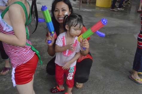 Mom and daughter with water gun enjoying enjoying the festival