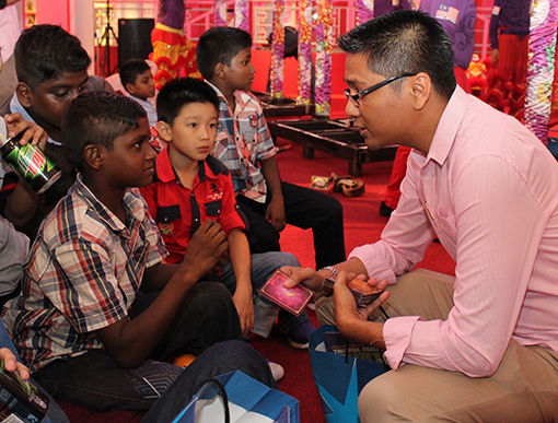 Encik Azizul Hisham Ahmad, Centre Manager of eCurve having a chat and giving out Ang Pows to the children.