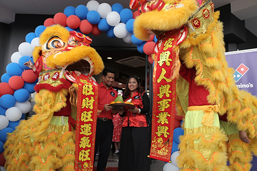 Lion dancers offering oranges and pamelo to Shamsul Amree, General Manager, Operations, Domino's Pizza Malaysia and Singapore (left) together with Linda Hassan, Deputy General Manager, Marketing, Domino's Pizza Malaysia and Singapore (right) as a symbol of prospertiy and good luck to usher in the upcoming Lunar New Year. 
