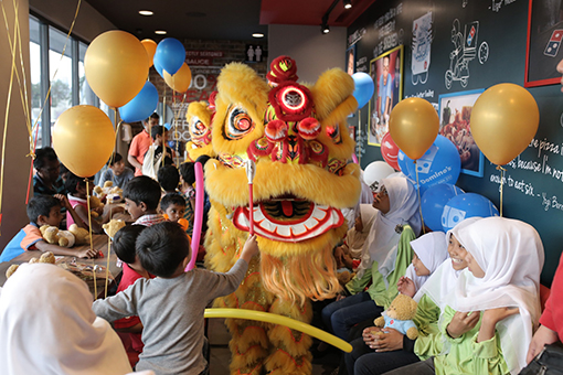 The lion dancers showing off their acrobatic skills to the excited children.