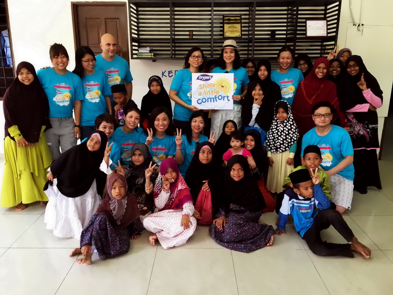 Evelyn Chan, Marketing Director of SCA Hygiene Marketing Malaysia Sdn Bhd (center left), Elaine Daly, Drypers’ Moms of Malaysia (MOM) advocate (center right), volunteers with children at the orphanage