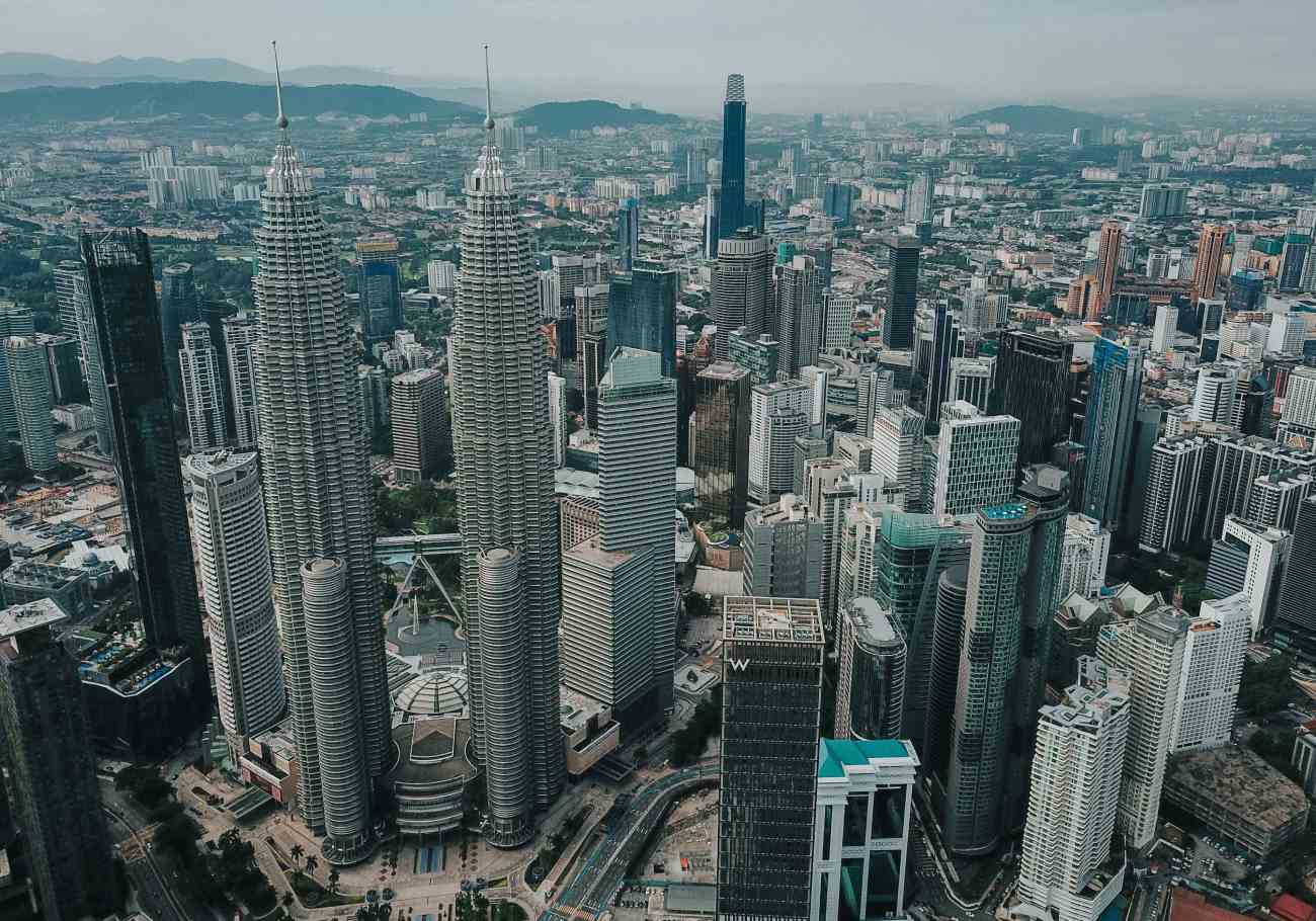 Mesmerizing cityscape of Kuala Lumpur at night, featuring the Petronas Twin Towers and other landmarks, emphasizing its growing popularity as a top travel destination according to Tripadvisor 2024 rankings.