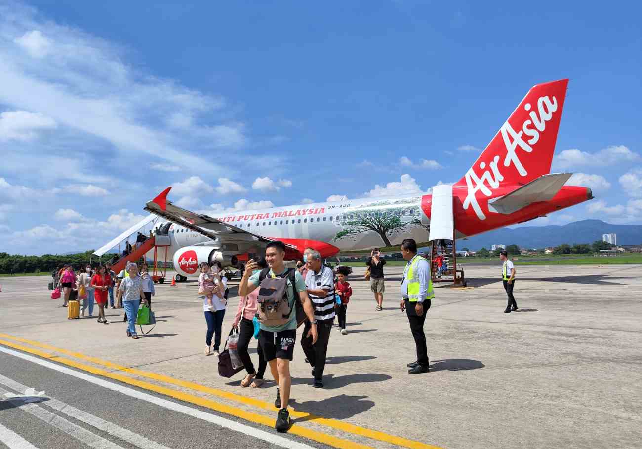 Passengers alighting the AirAsia flight, ready to travel.