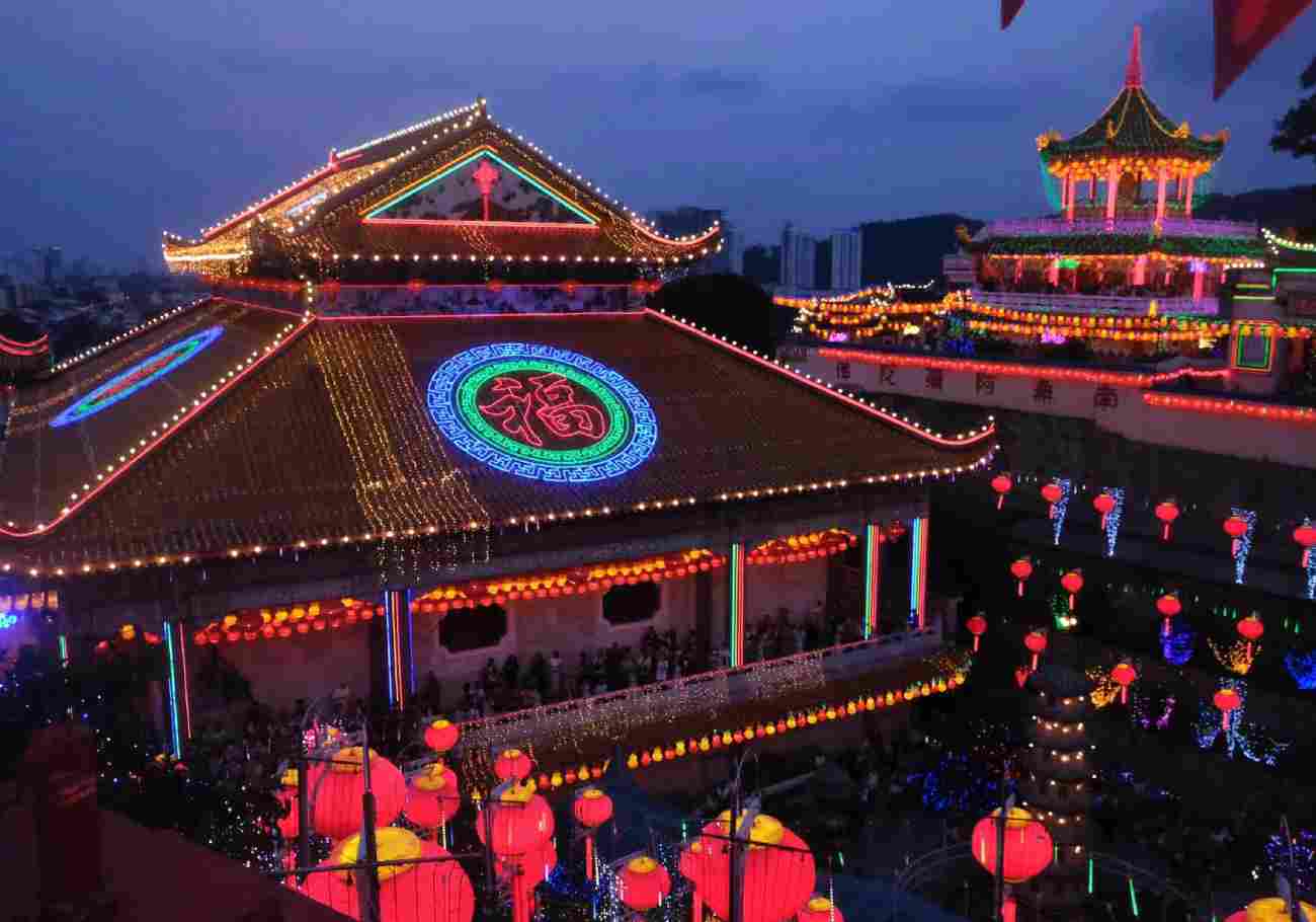 Image of Kek Lok Si Temple illuminated with colorful neon lights and lanterns at night.