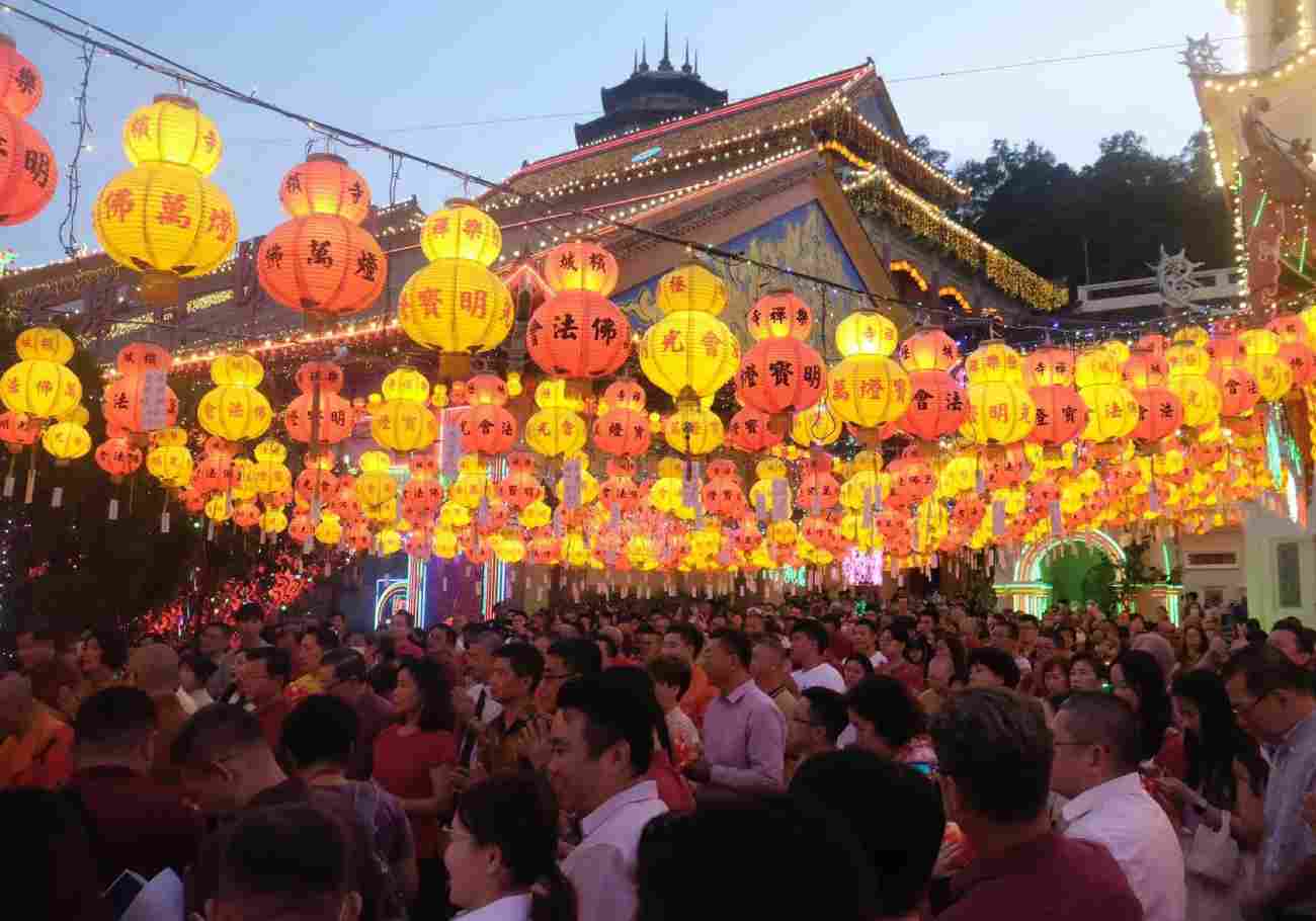 People enjoying the festive atmosphere and colorful lighting display at the event at Kek Lok Si Temple.