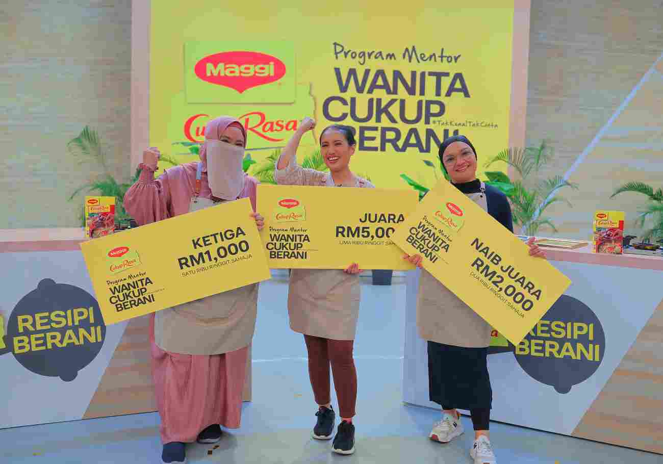 Image of Nur Hanie Mohammed and the runners up of Program Mentor Wanita Cukup Berani by Maggi holding their mock-cheque, smiling confidently.